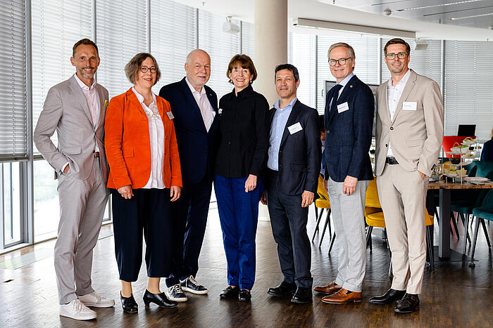 Mehrere Personen stehen für ein Gruppenfoto in einer Reihe.